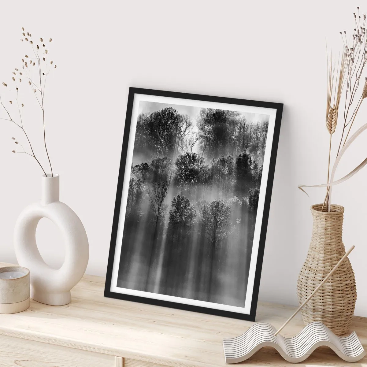 Poster in een zwarte lijst - Zwart-wit bos in de mist met zonnestralen - 50x70cm - In stromen van licht - Moderne wanddecoratie voor woonkamer en slaapkamer ARTTOR